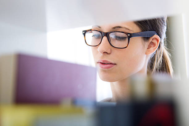 istock student girl looking for a book in the library 454220435