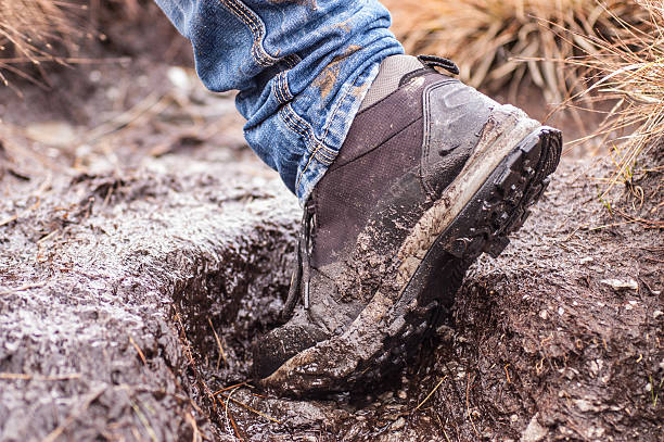 Side view of a single hiking shoe covered in mud taken while walking
