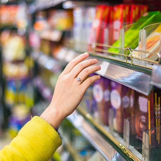 istock Close-up of woman's hand selecting item from store shelf 454228009
