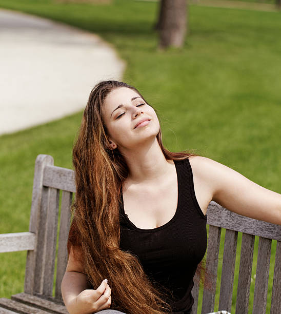 istock pretty young girl on a bench 454231697