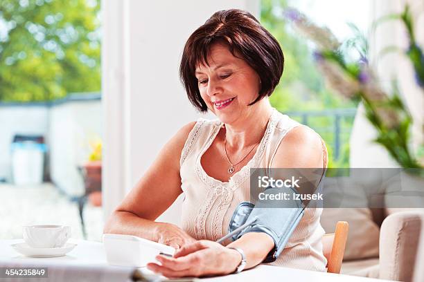 Woman Checking Blood Presure Stock Photo - Download Image Now - Blood Pressure Gauge, Women, Domestic Life
