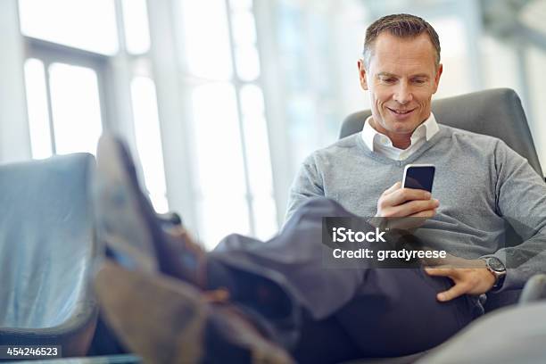 Sending An Old Client A Friendly Text Stock Photo - Download Image Now - Mature Men, Office, Using Phone