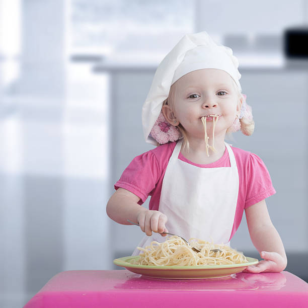 istock Little girl with spaghetti 454250469