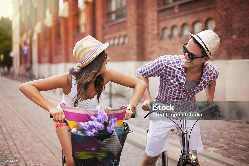 Happy couple chasing on bike in the street Cycling Stock Photo