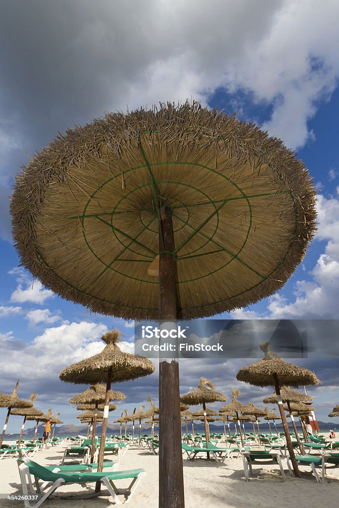 Sun shade on an empty beach Low angle shot of a beach umbrella on an empty beach in Alcudia, Spain Bay of Alcudia Stock Photo