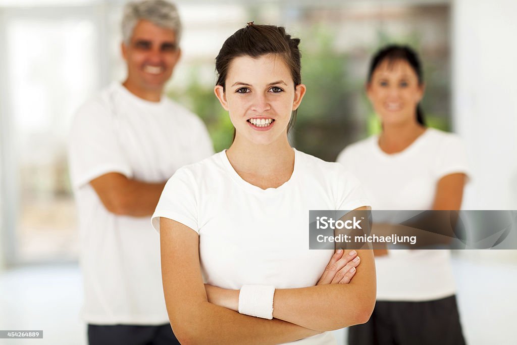 active teenage girl and parents smiling active teenage girl arms folded standing in front of parents Active Lifestyle Stock Photo