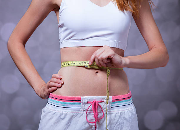 istock Beautiful and strong women's abs with metre. 454266819