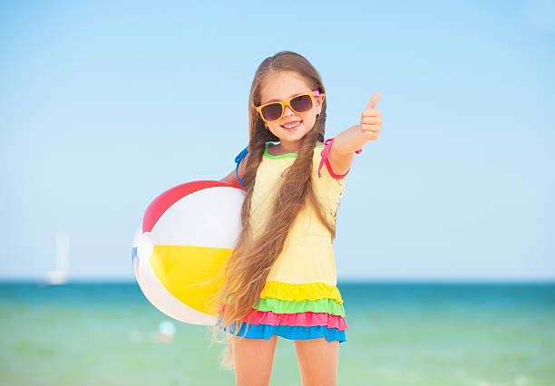 istock Little girl playing on beach with ball. 454274173