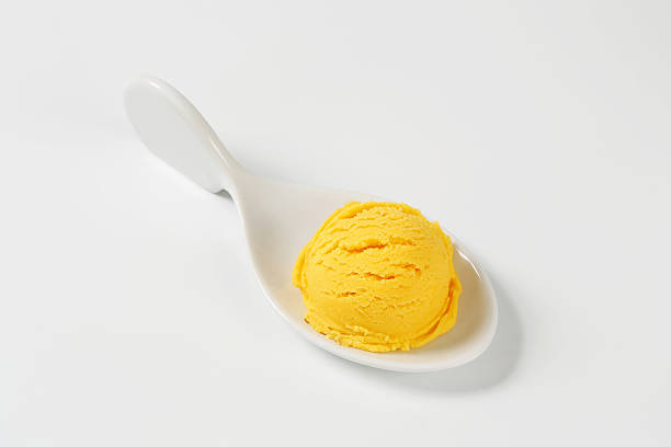 istock Scoop of orange ice cream in a spoon 454276315