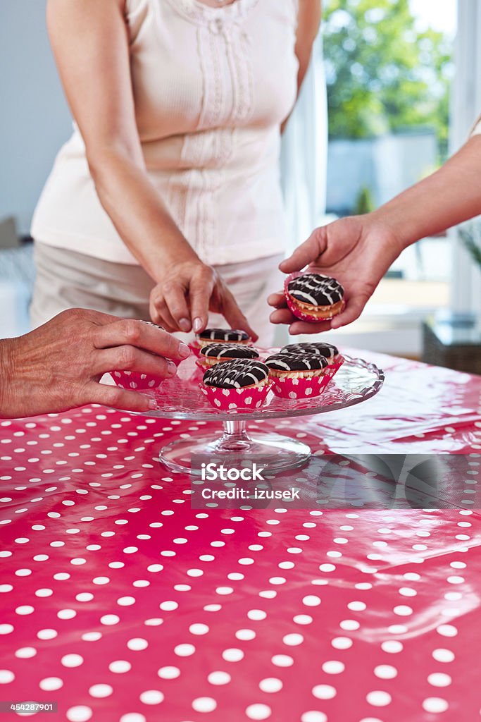 Senior party Close up of senior women hands reaching for the cookies. 60-64 Years Stock Photo Senior party Close up of senior women hands reaching for the cookies. 60-64 Years Stock Photo