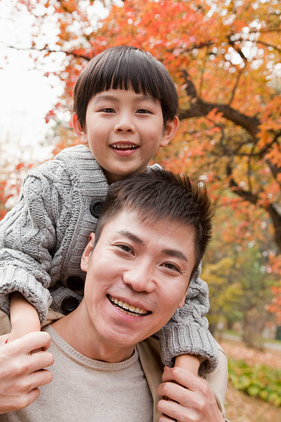 istock Little boy sitting on his fathers shoulders 454289299