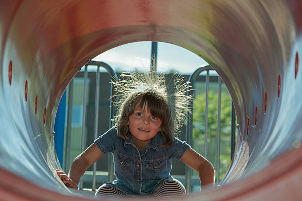 child playing inside playground tube stock photo