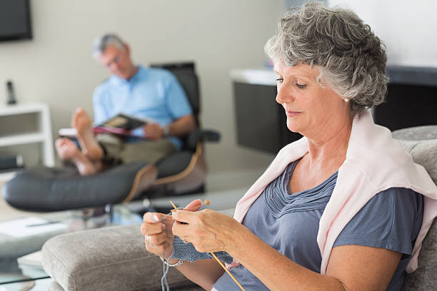 istock Mature woman knitting while her husband is reading 454299461