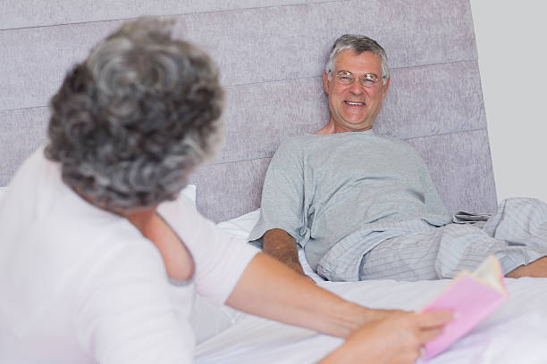 istock Mature woman holding book and talking with her husband 454299537