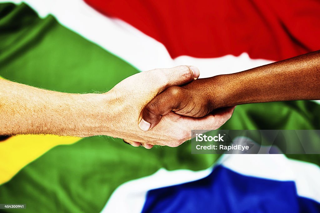 O arco-íris nação: interracial aperto de mão contra Bandeira da África do Sul - Royalty-free Bandeira da África do Sul Foto de stock