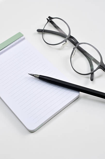istock Eye glasses, blank notepad, and mechanical pencil 454301729