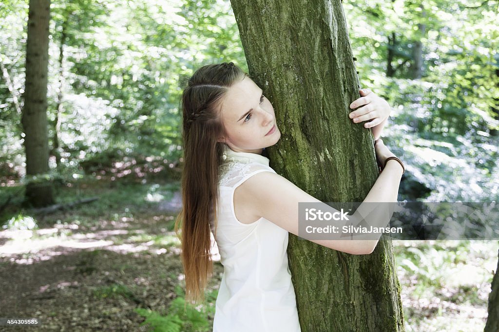 Ragazza adolescente nei boschi accogliere albero - Foto stock royalty-free di 16-17 anni