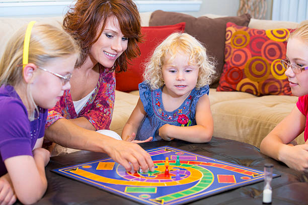 istock Mom and three kids playing an exciting board game 454311121