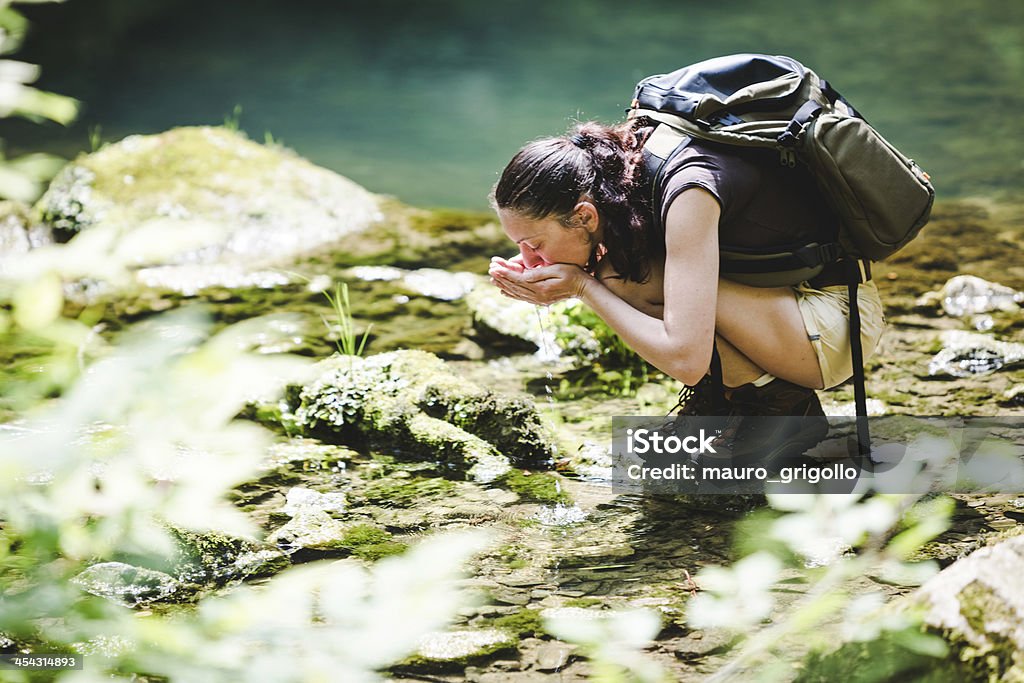 Randonneur boire de l'eau dans une forêt brook - Photo de 30-34 ans libre de droits