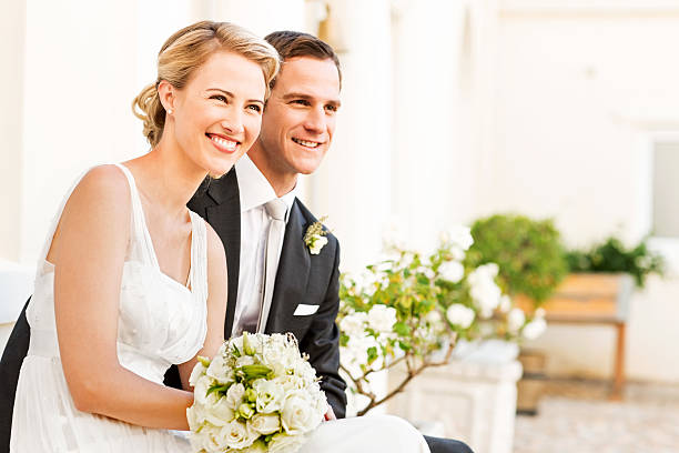 istock Bride And Groom With Flower Bouquet Looking Away 454316839