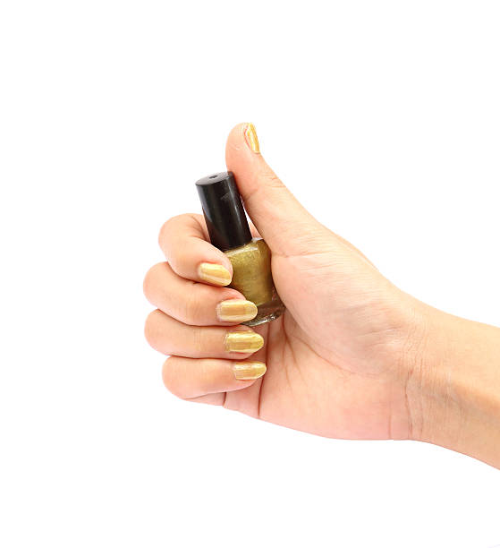 istock hand with golden nail polish bottle on white background 454317761