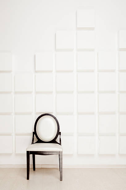 istock Black-white chair near white wall in a studio 454318267