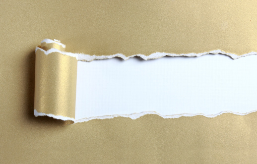 Ripped gold color paper over white background