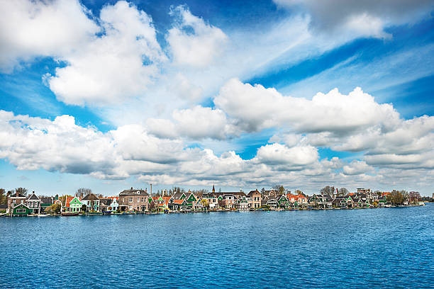 Beautiful Sumer Sky over Zaanse Schans. Visible are many traditional dutch houses and beautiful blue sky with fantastic cloudscape over the river. Zaanse Schans, one of the popular tourist attractions of The Netherlands. Zaandam, Netherlands.