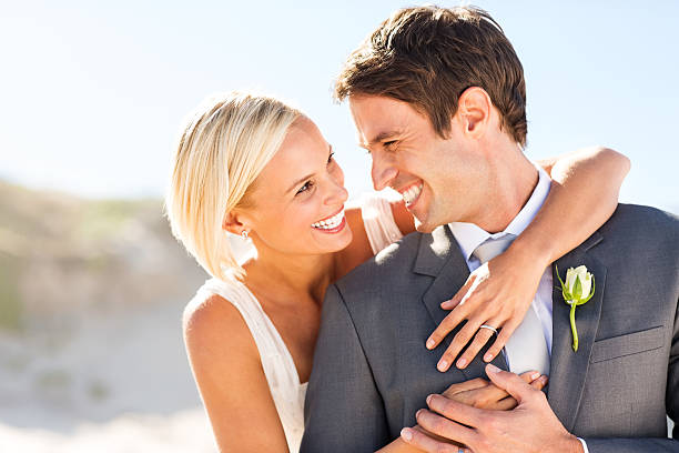 istock Bride And Groom Looking At Each Other On Beach 454338327