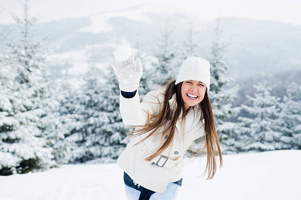 istock Young woman throwing snowball 454340229