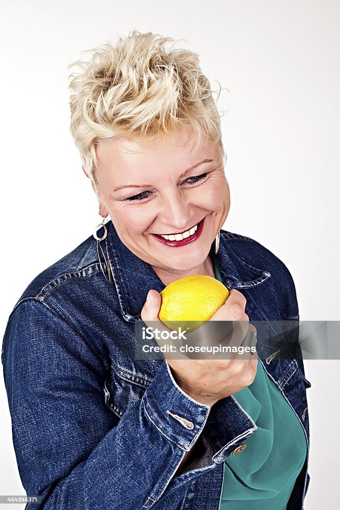middelaged Piękna kobieta jedzenie świeża cytryna - Zbiór zdjęć royalty-free (40-49 lat)