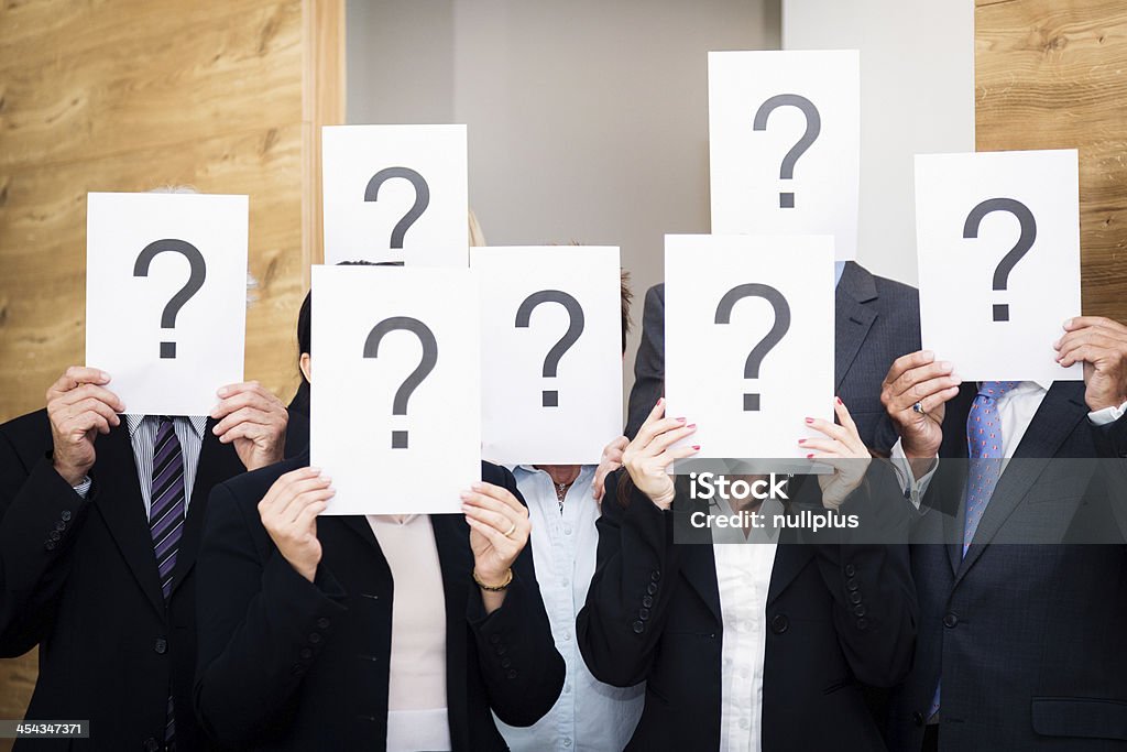 clueless business team business team holding pieces of paper with question marks. concept shot used to depict cluelessness or confusion. Adult Stock Photo