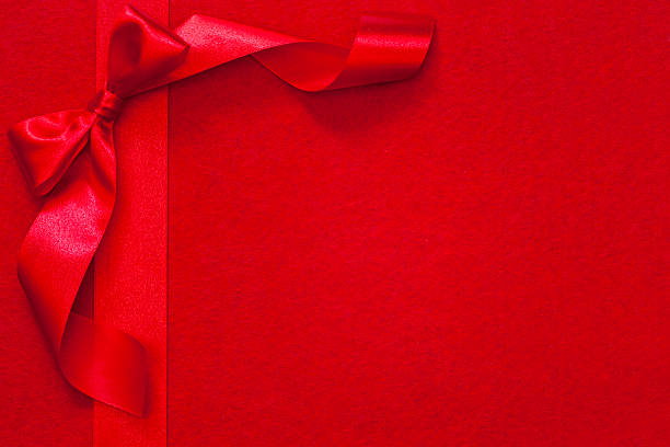 istock Christmas ribbon with bow on red fabric 454351841