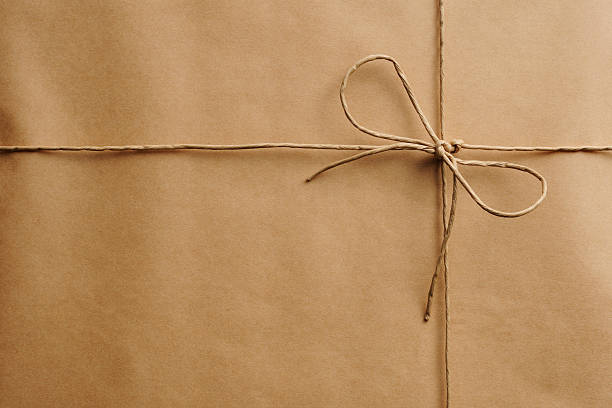 close-up of brown завёрнутый пакет с завязками - string package brown paper стоковые фото и изображения