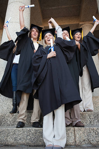istock Young smiling graduating students raising their diplomas 454354343