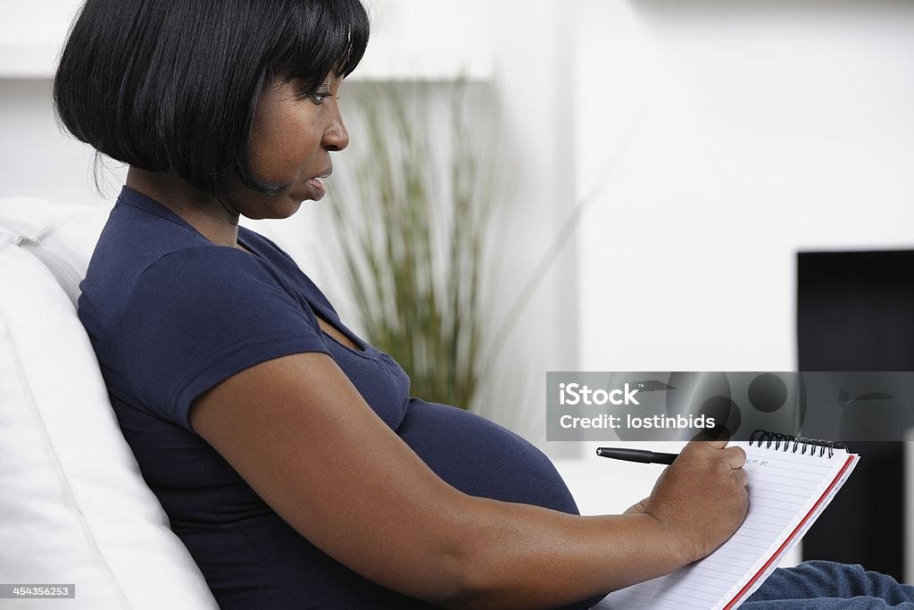 Primer plano de una mujer embarazada de escritura - Foto de stock de 30-39 años libre de derechos