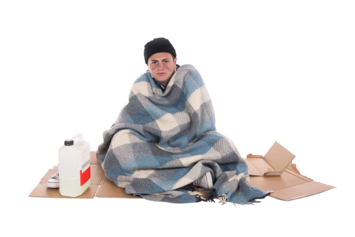 Shooting in studio of a homeless person sitting on cardboard