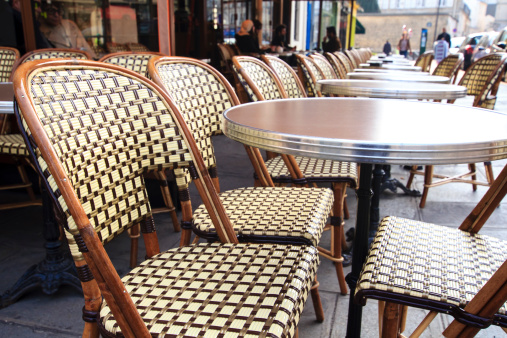 Traditional parisian coffee house / Paris - traditional french cafe with it's round tables and chairs outdoors on the sidewalk, wide-angle lens