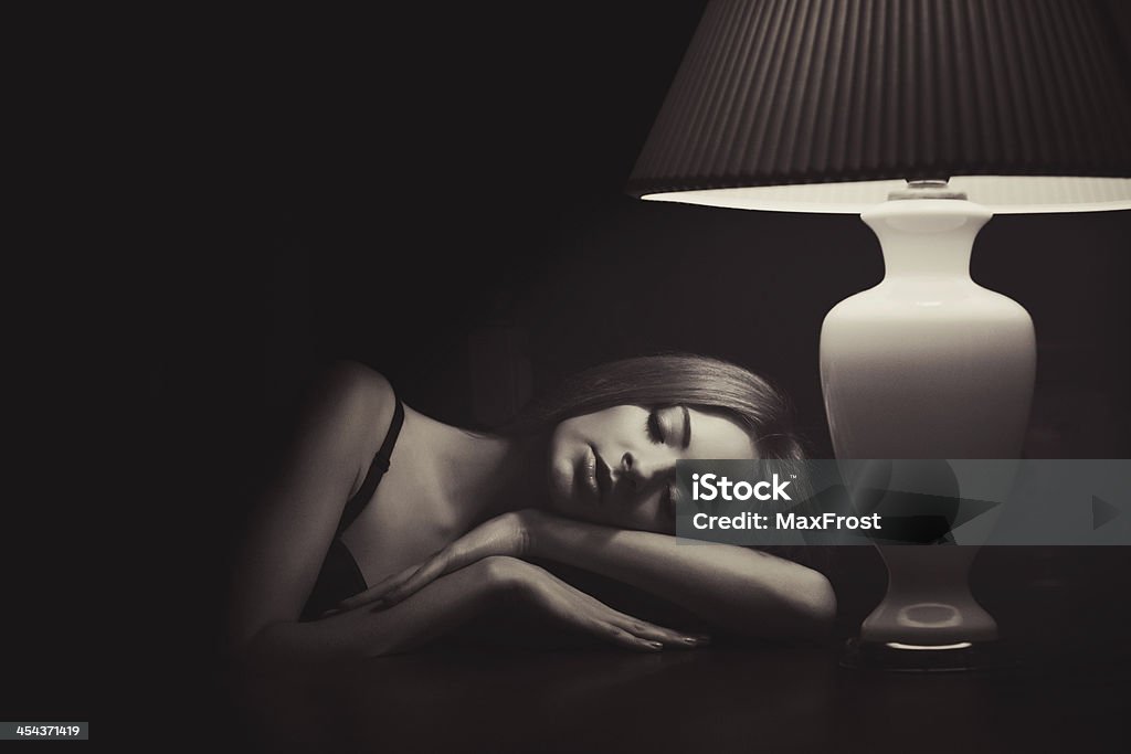 low key sepia portrait of sleeping near the lamp woman One Woman Only Stock Photo