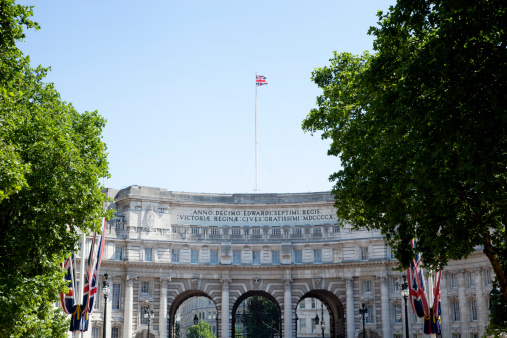 A vertical shot of the Palace of Westminster with the UK flag in London