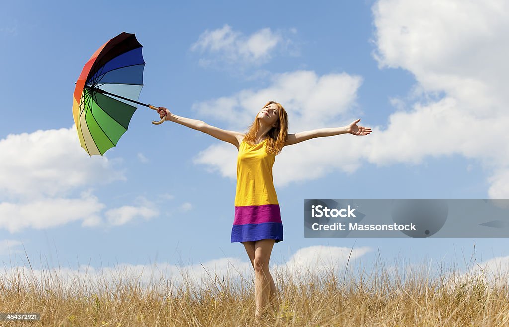 Girl with umbrella at meadow. Adult Stock Photo