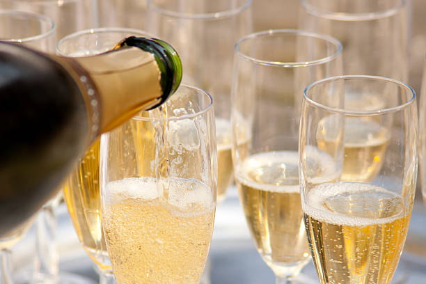 Close-up of elegant glasses filled with champaign Champaign being pored into glasses. champagne stock pictures, royalty-free photos & images