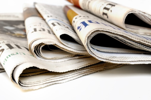 Stack of international newspapers on white background