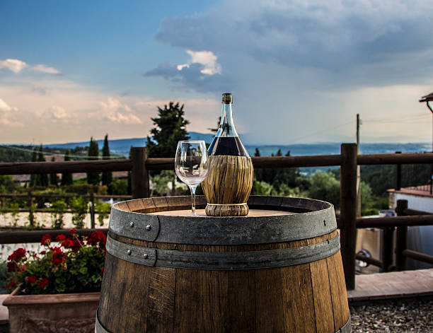 Chianti A bottle of Chianti with an empty glass on a barrel chianti region stock pictures, royalty-free photos & images