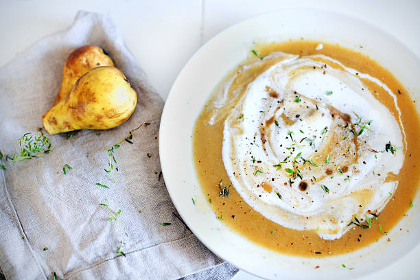 Sweet potato and rutabaga creamy soup with pears, herbs stock photo