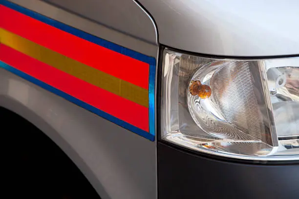 A close up shot of the headlamp and wing of a modern British police car