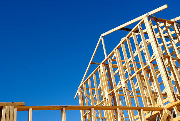 istock A wooden house frame against a bright blue sky 454407171