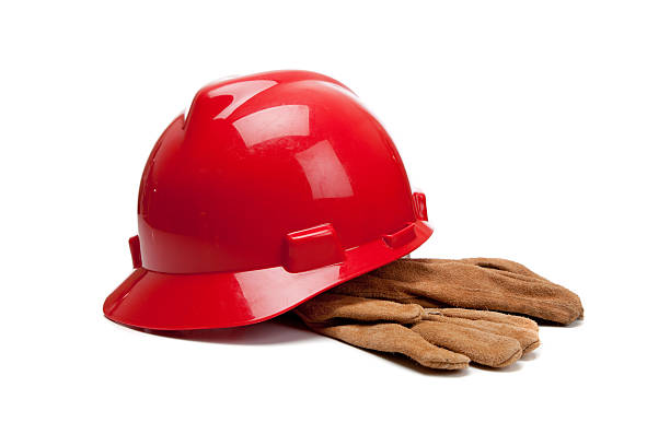 Red hard hat and leather work gloves on white stock photo