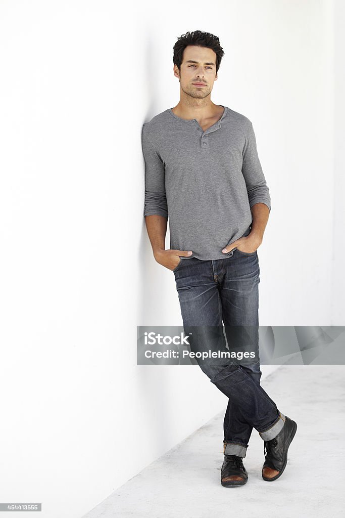 He's got style Portrait of a handsome young man leaning against a wall with his hands in his pockets Bachelor Stock Photo