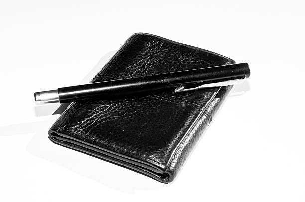 Black wallet with pen isolated on white background stock photo